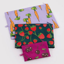 Three nylon zip pouches stacked, each with a different fruit print: a lavender carrot pattern, a dark green strawberry pattern, and a magenta cherry pattern.