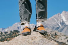 Hiker wearing Bedrock Mountain Clog in chanterelle Suede on the top of a colorado peak  