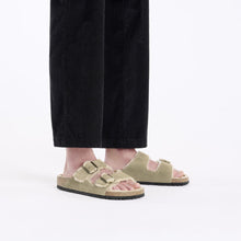 Person wearing taupe sandals styled with black pants 
