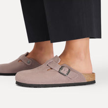 Pair of light purple suede clogs with a cork sole styled in black pants 