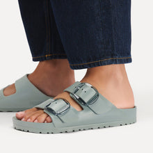 Light green sandals with buckles styled with dark jeans 