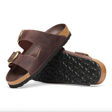 A pair of dark brown double-strap slide sandals with cork midsoles and black eva soles