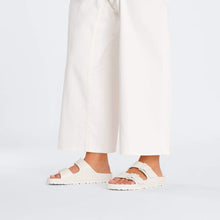 White eva sandals styled with white pants 