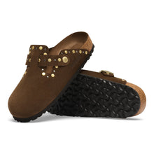 A pair of brown suede clogs with gold metal studs and buckles