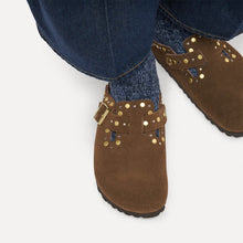 Brown suede shoes with gold studs styled with blue jeans and blue socks