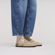 Beige clog worn with blue jeans and beige socks 