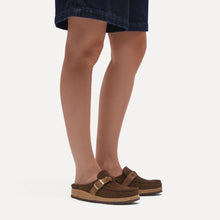 Brown suede clogs styled with denim shorts