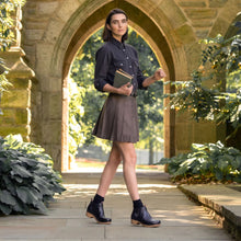 A woman styled in the black Dansko chelsea ankle boots