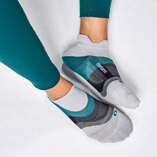 Gray socks with green accents worn with green leggings 