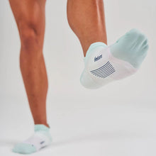 Light green ankle socks with a brand logo worn by a person on a light gray background