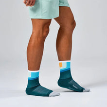 Person wearing green socks with colorful stripes
