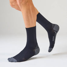 Person wearing black socks with a textured pattern 