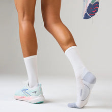 Person wearing white socks and colorful running shoes 