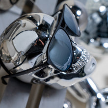 Sunglasses on a metallic surface with blurred background