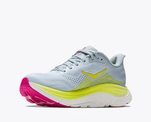 A light blue athletic running shoe with a bright yellow accents, a thick white midsole, and a pink and yellow outsole