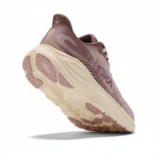 A Hoka running shoe in a dusty mauve pink colorway with a chunky cream-colored midsole and white laces