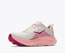 A women's running shoe featuring a white mesh upper, a thick light pink midsole, and magenta-pink accents on the side