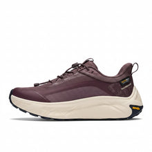 A Hoka hiking sneaker featuring a dark plum purple upper, a thick cream-colored midsole, and a black Vibram outsole.