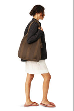 Woman carrying a brown tote bag