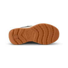 The textured brown rubber outsole of a shoe