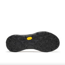 The black rubber outsole of a hiking shoe, showing deep lugs and a small yellow Vibram logo badge