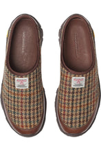 A pair of Merrell slip-on clog shoes in a brown and beige houndstooth pattern