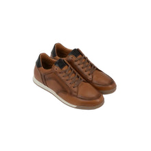 A pair of brown leather low-top sneakers with dark heel tabs and off-white soles,