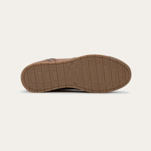 A brown shoe sole with a textured tread pattern