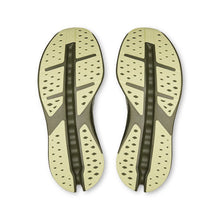 A pair of athletic shoes displaying their sole patterns in olive green 