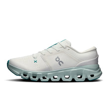A white On running shoe with light green accents 