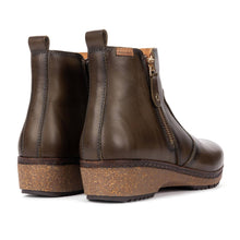 A pair of dark brown leather ankle boots with cork wedge heels and side zippers