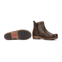 A pair of dark olive leather ankle boots with side zippers and wedge heels