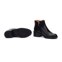 A pair of black leather ankle boots showing a side zipper