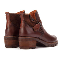 A pair of dark brown leather ankle boots with a chunky stacked wood-look heel and a side buckle strap detail