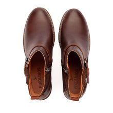 A pair of dark brown leather ankle boots featuring a side zippers and metal snap buttons