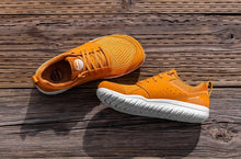 Lems Primal Zen minimalist shoe in Nugget orange styled on wood floor 
