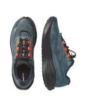 Two Salomon trail running shoes shown from the top and side views featuring a textured dark teal-blue and black mesh upper with bright orange lace hoops