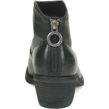 Black leather ankle boot shown from the back, featuring a zipper with a prominent circular silver-tone metal pull tab 