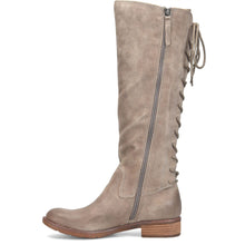 A tall taupe suede knee-high boot with a side zipper and lace-up detailing on the outer side