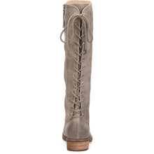 A tall knee-high boot in taupe suede, shown from the back. Featuring a lace-up front, a side zipper, and a stacked wood-look heel