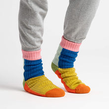 Colorful striped socks worn with gray pants 